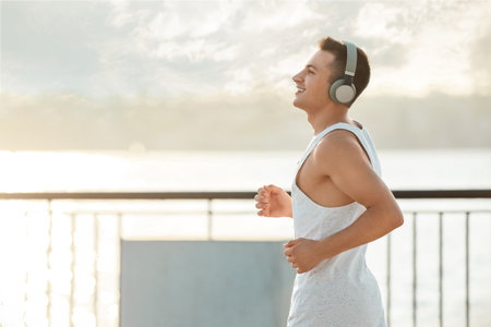 Sporty young man with headphones running outdoors