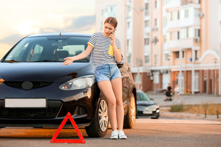 Stressed woman talking by phone near car outdoorsの写真素材