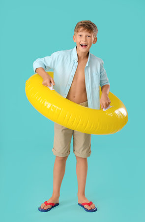 Cute little boy with inflatable ring on color backgroundの写真素材