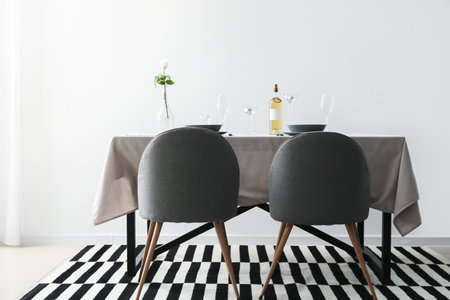 Table and chairs near light wallの写真素材