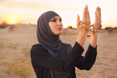 Beautiful Muslim woman praying in desertの写真素材
