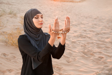 Beautiful Muslim woman praying in desertの写真素材