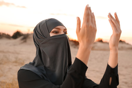 Beautiful Muslim woman praying in desertの写真素材