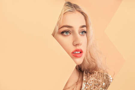 Young woman with beautiful makeup and paper sheets on color background