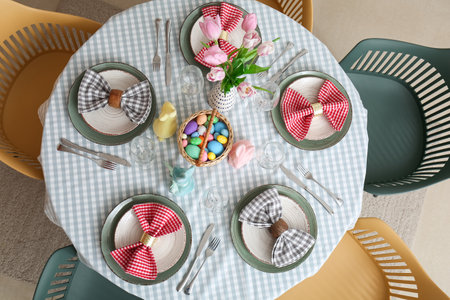 Table with tulip flowers, painted eggs and bunnies served for Easter celebrationの写真素材