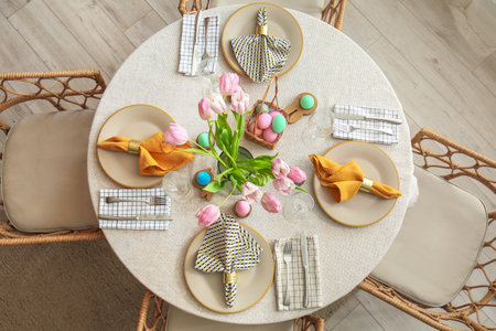 Table with tulip flowers and painted eggs served for Easter celebrationの写真素材