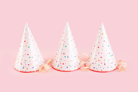 Party hats and serpentine on pink backgroundの写真素材