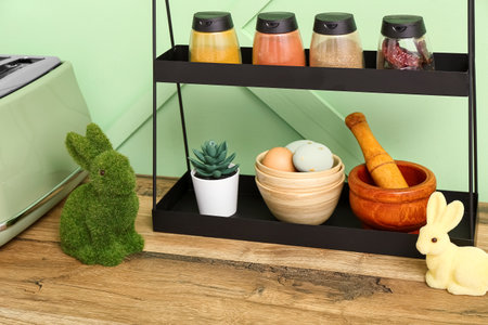 Easter bunnies and painted eggs on kitchen counter near green wallの写真素材