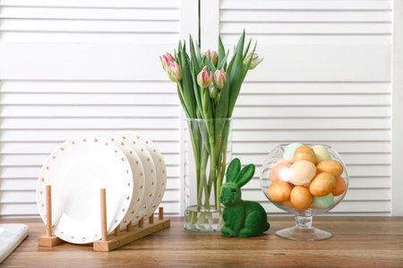 Easter eggs, bunny and vase with tulip flowers on kitchen counterの写真素材
