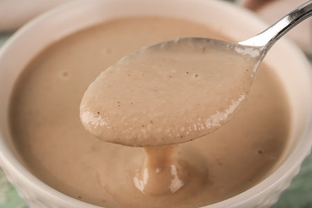 Spoon and bowl with tasty tahini, closeupの写真素材