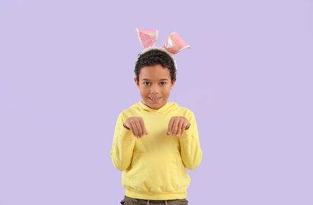 African-American little boy in bunny ears on lilac background