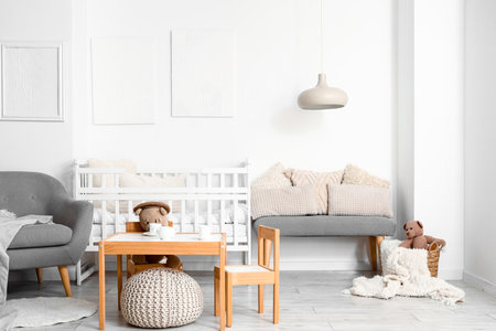 Interior of light children's bedroom with baby crib, table and chairsの写真素材