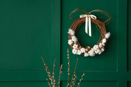 Willow branches and Easter wreath on green wallの写真素材