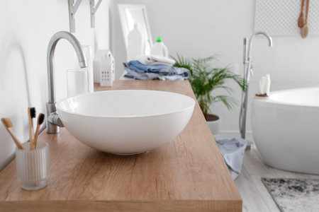 White sink on counter in light bathroomの写真素材
