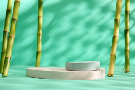 Green bamboo stems and plaster podiums on turquoise backgroundの写真素材