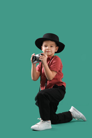 Cute little photographer with camera on green backgroundの写真素材
