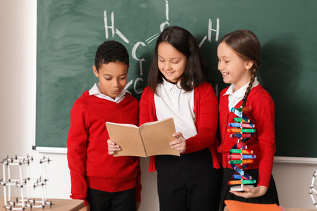 Little children with copybook and molecular model in science classroomの写真素材