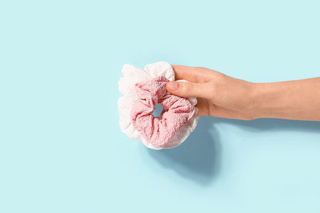 Female hand with scrunchies on blue backgroundの写真素材