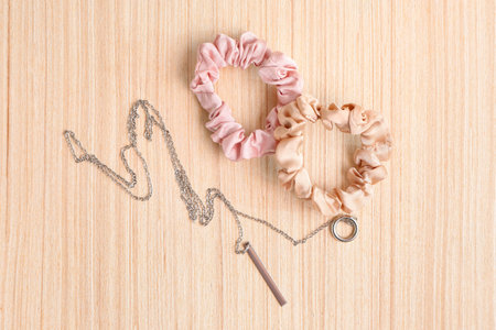Stylish scrunchies and necklace on wooden backgroundの写真素材