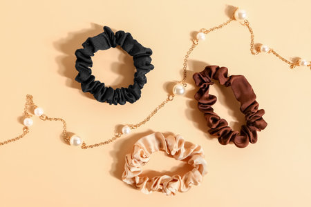 Silk scrunchies and beautiful necklace on color backgroundの写真素材