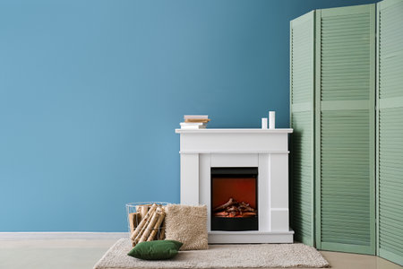 Interior of cozy living room with green folding screen and fireplaceの写真素材