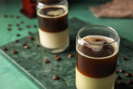 Board with glasses of tasty Cafe Bombon on color background