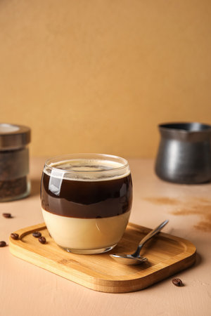Wooden board with glass of tasty Cafe Bombon on color backgroundの写真素材