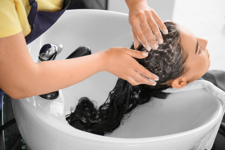 Female hairdresser working with client in salonの写真素材