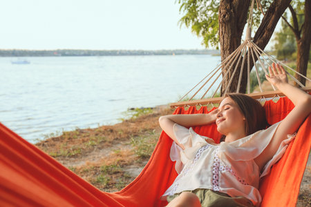 Young woman relaxing in hammock outdoorsの写真素材