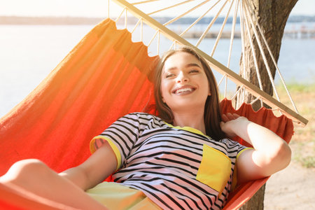 Young woman relaxing in hammock outdoorsの写真素材