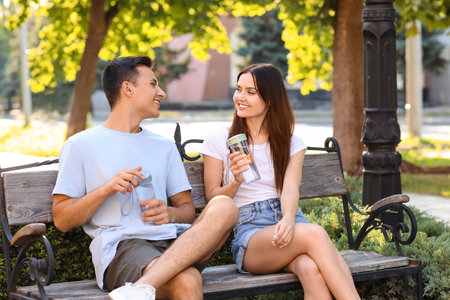 Young couple with bottles of water in the parkの写真素材