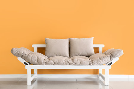 Modern sofa near color wall in room