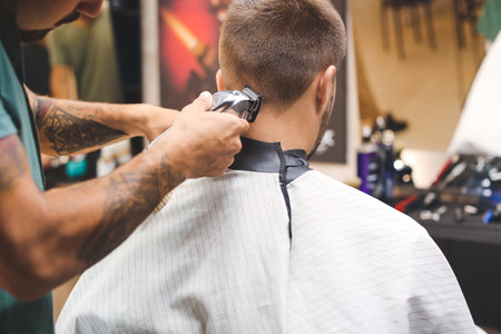 Professional hairdresser working with client in barbershopの写真素材