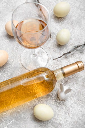 Composition with bottle of wine, glass and Easter eggs on light background, closeupの写真素材