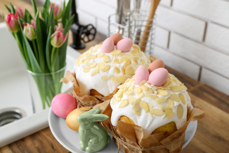 Dessert stand with Easter cakes, painted eggs and bunny on kitchen counter