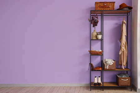 Stylish coat rack near lilac wall in hallの写真素材