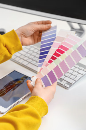 Female tailor with palettes at table, closeup