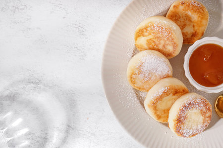 Plate with delicious cottage cheese pancakes and jam on light background, closeupの写真素材