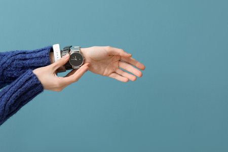 Woman with stylish wrist watch on blue backgroundの写真素材