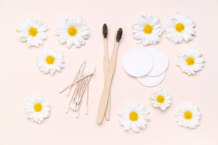 Composition with toothbrushes, cotton, pads, swabs and chamomile flowers on color backgroundの写真素材