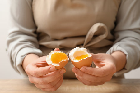 Woman with boiled egg at table, closeupの写真素材