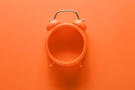 Alarm clock on orange backgroundの写真素材