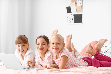 Cute little girls watching cartoons at homeの写真素材