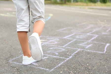 Little girl playing hopscotch outdoorsの写真素材