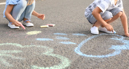 Little children drawing with chalk on asphaltの写真素材