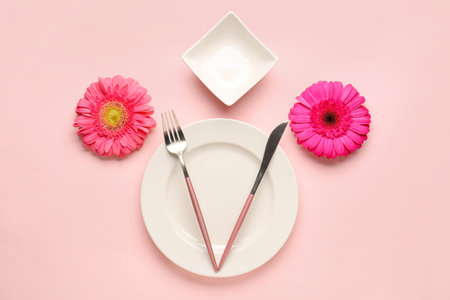 Table setting with beautiful gerbera flowers on pink backgroundの写真素材