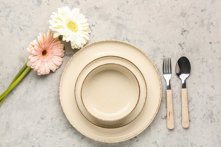 Table setting with beautiful gerbera flowers on gray grunge backgroundの写真素材