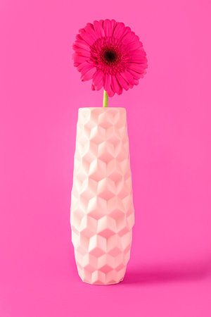 Vase with beautiful gerbera flower on pink backgroundの写真素材