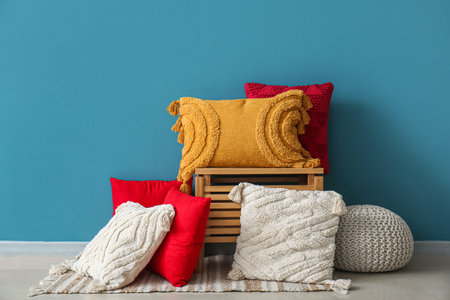 Stylish decorative pillows near blue wallの写真素材