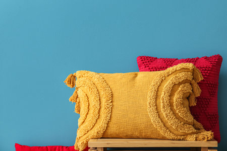 Stylish decorative pillows near blue wallの写真素材